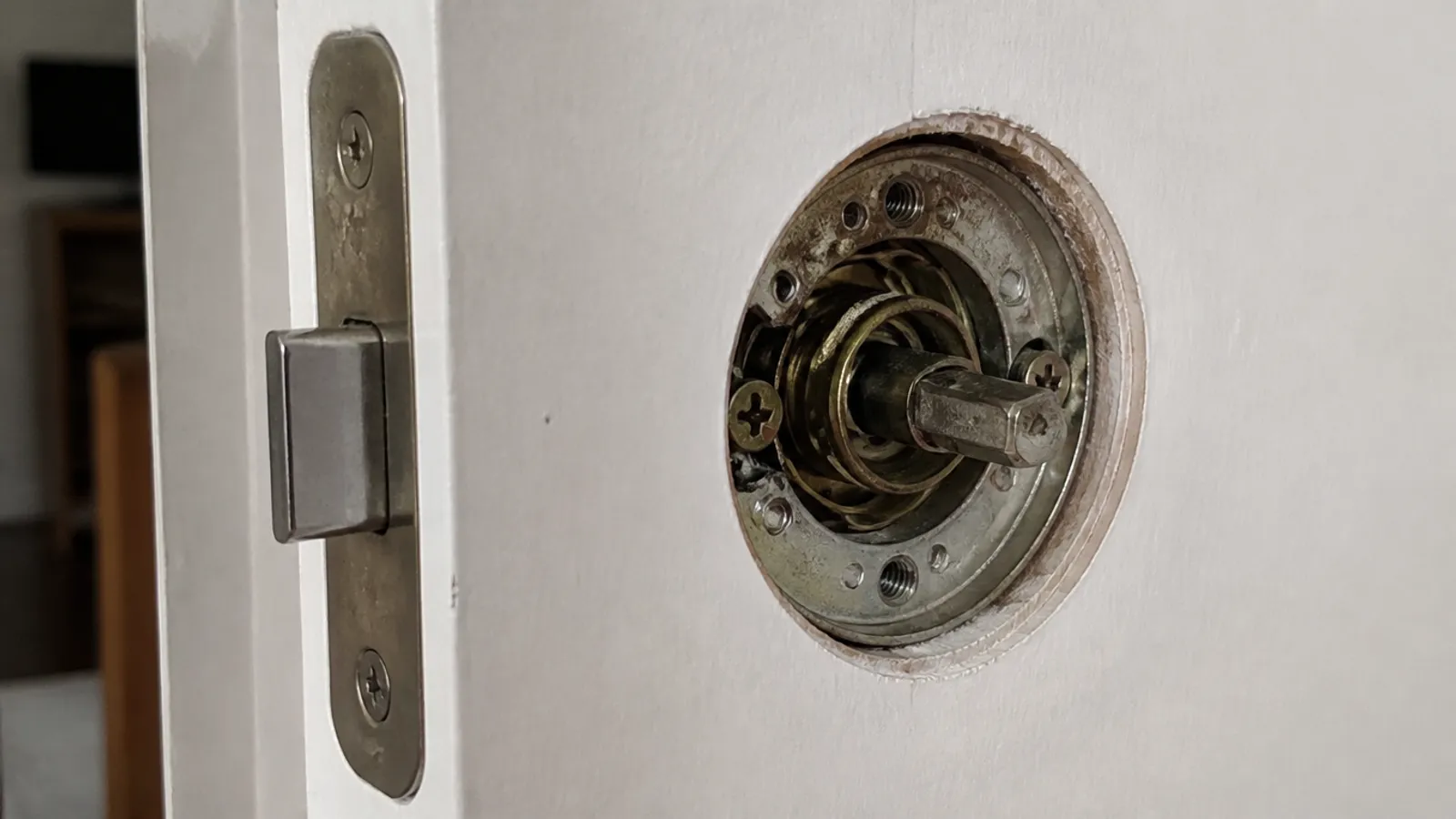 Cerradura de puerta parcialmente desmontada para decidir si se repara o se cambia