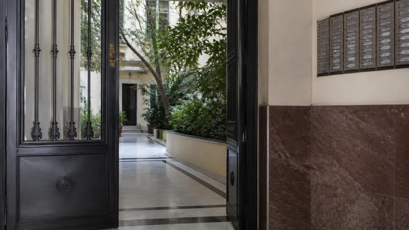 Portal comunitario con puerta metálica y acceso de vecinos en Valencia